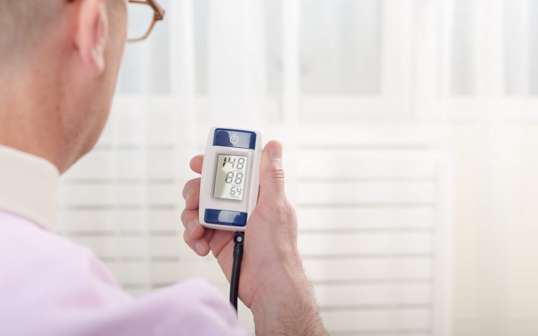 Man read measurement result from digital blood pressure monitor