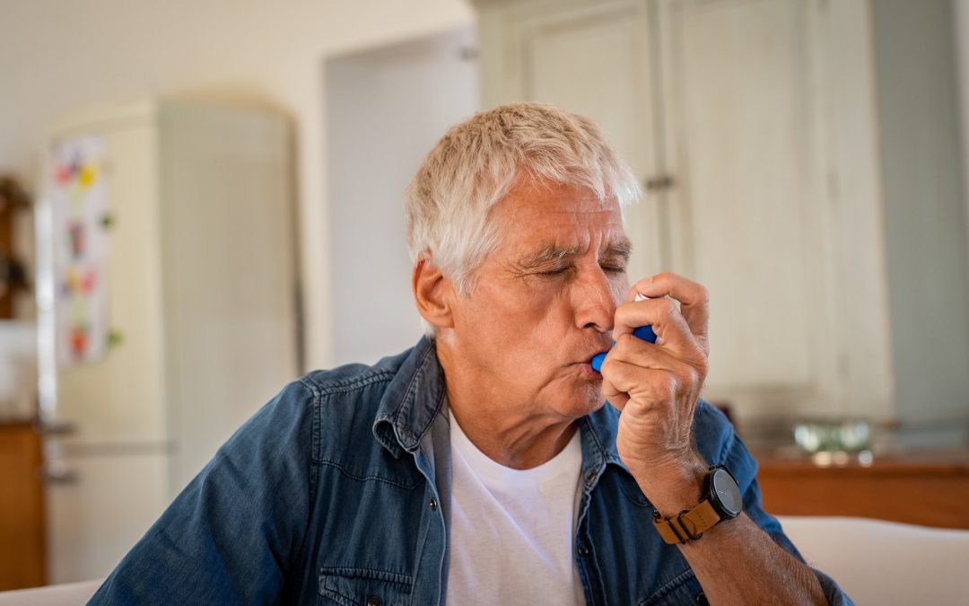 Senior man using asthma pump