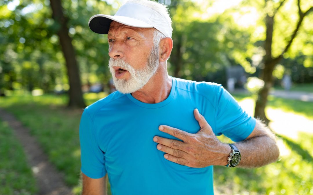 Senior man with chest pain suffering from heart attack during jogging