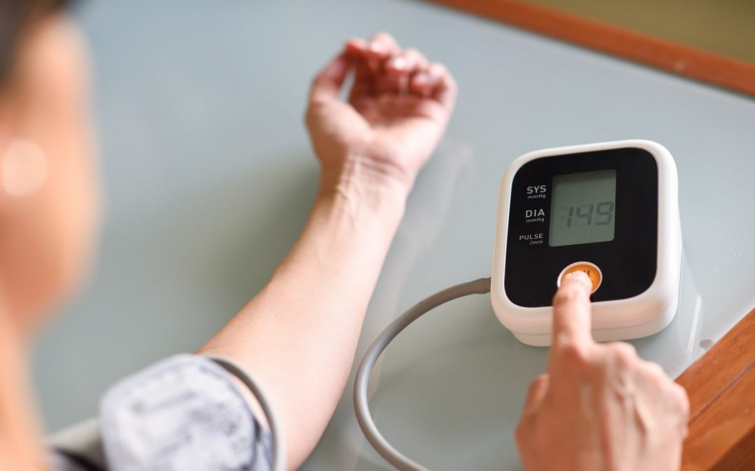 Woman measuring her own blood pressure at home